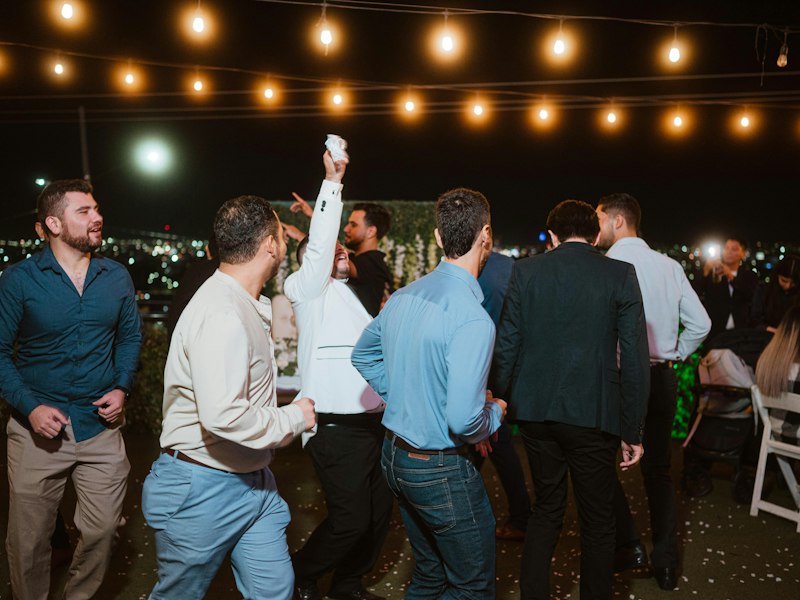 Guests dancing under string lights at an outdoor evening event