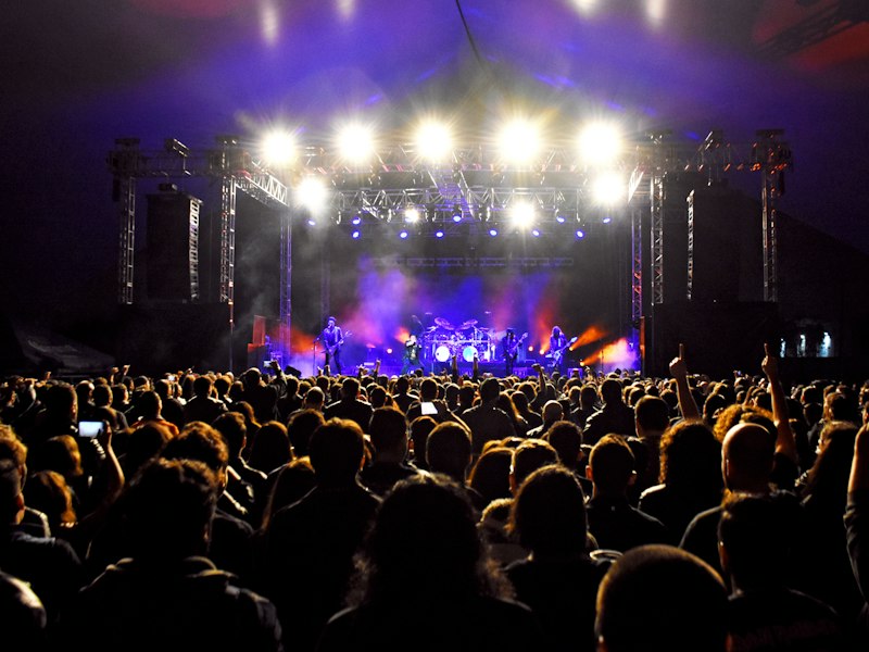 Audience facing a brightly lit stage at night