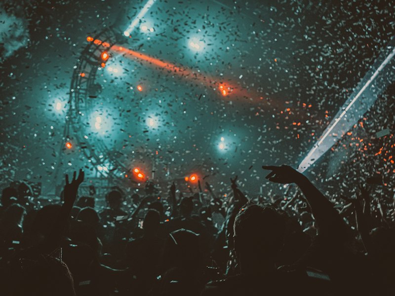 Crowd celebrating under warm and red stage lights