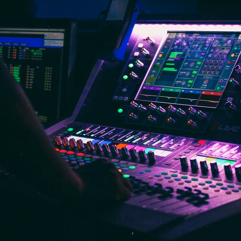Hands mixing live sound on a digital console